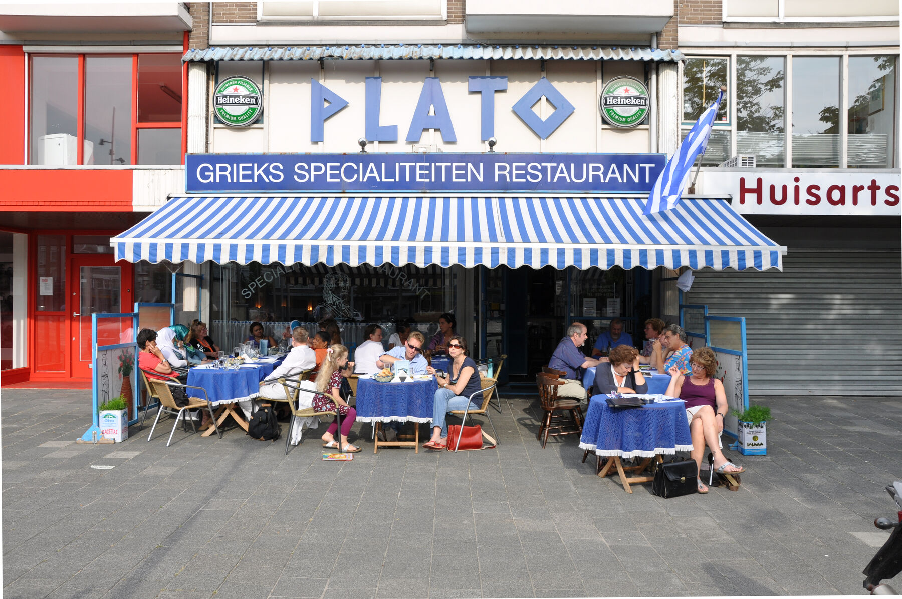 De gevel en het terras van Grieks Restaurant Plato aan het Confuciusplein